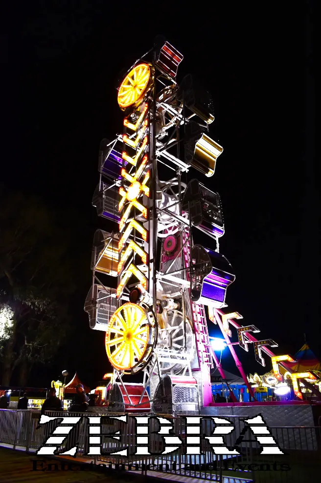 A large, colorful swing ride set up in a grassy field for an event by Zebra Entertainment, one of Southern California's premier carnival ride companies.