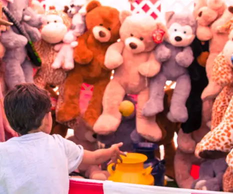 A carnival game booth filled with stuffed animal prizes, representing midway game rentals.