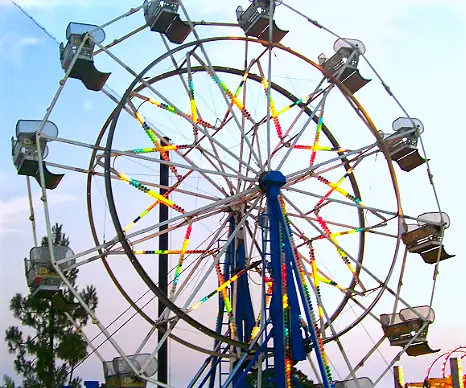 A large, colorful Ferris wheel at a carnival, representing amusement and carnival ride rentals.