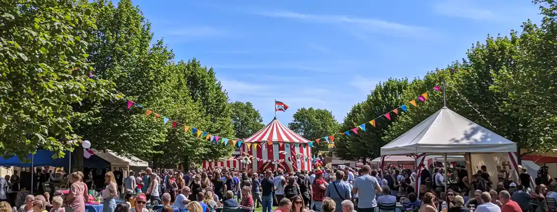 A large scale carnival event full of people and tents.